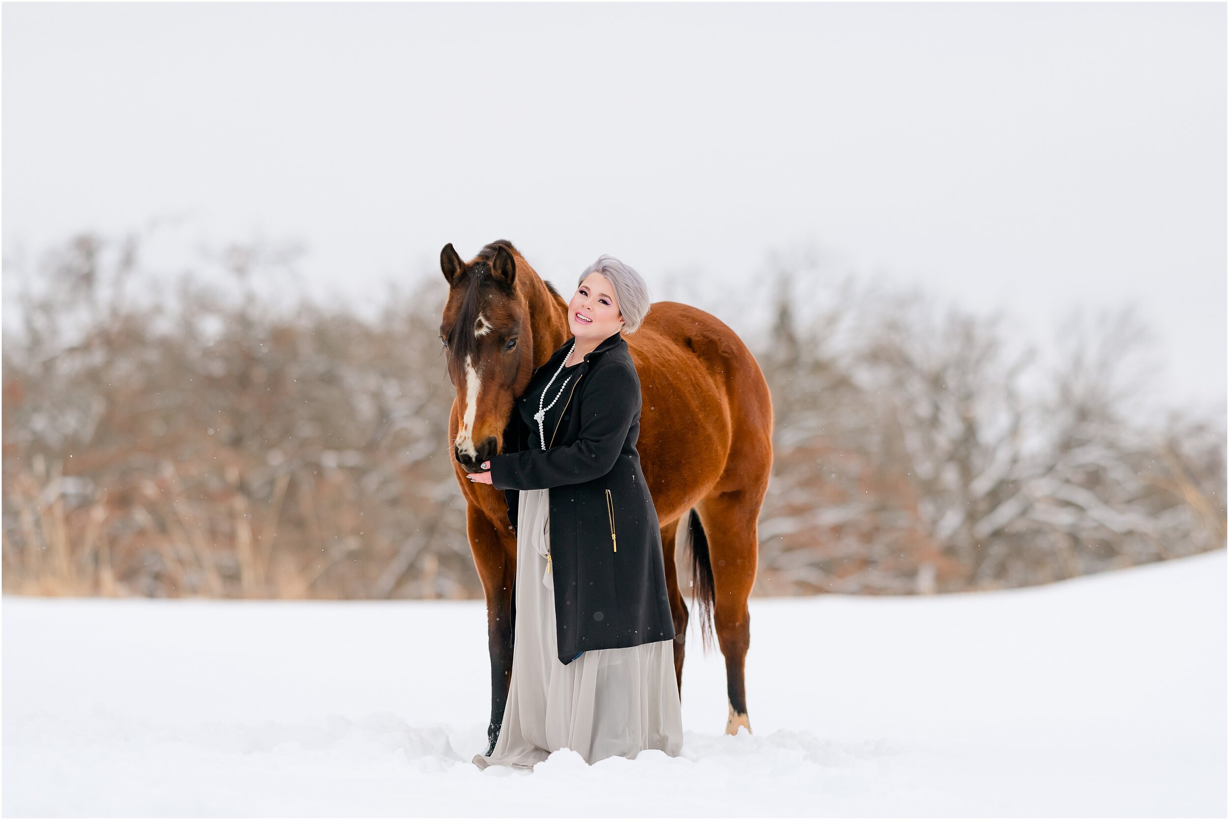  Girl with grey hair in a pixie cut with her senior quarter horse mare, standing in the snow in Arcadia Oklahoma. Grey skirt outfit for equestrian portrait session. Negative space in portrait, posing person and horse.  