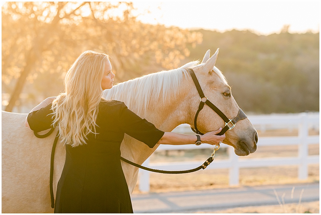 a blonde woman in a black dress cuddles with her palomino quarter horse in big spring texas
